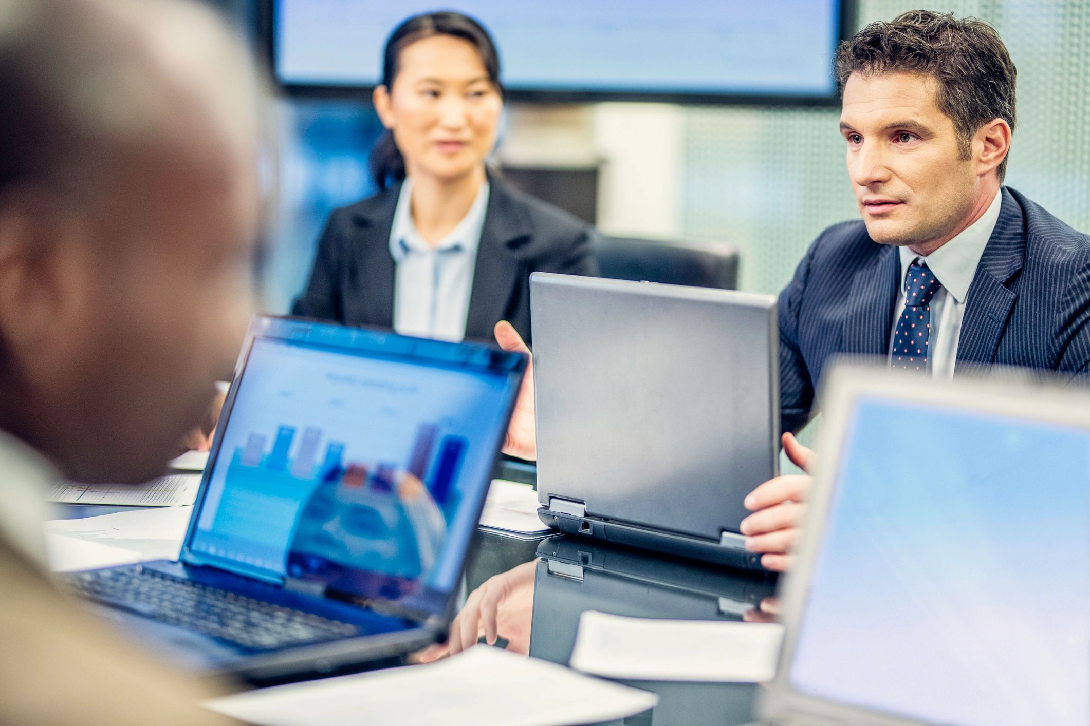 Professionals in a business meeting reviewing investment materials